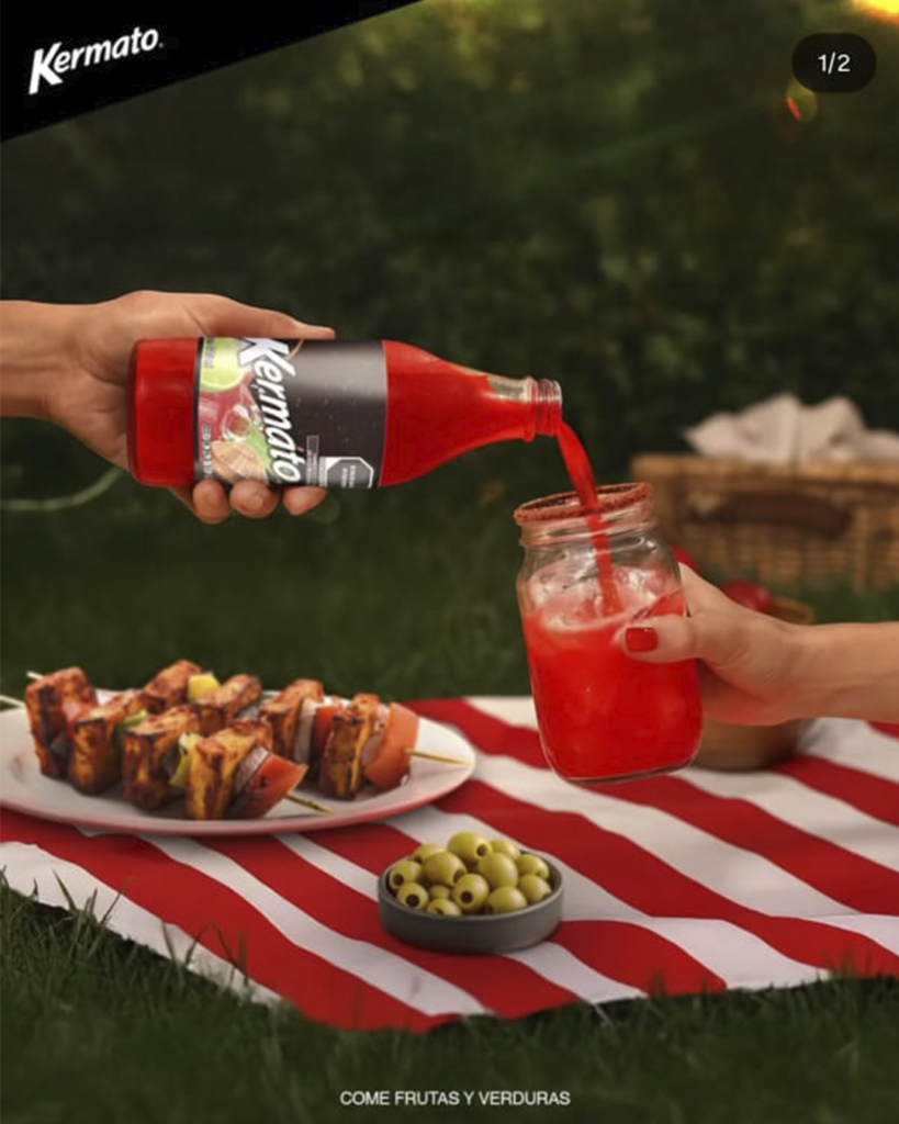 Vaso de michelada o clamato preparado con la bebida Kermato y chile en polvo, sostenido en un ambiente festivo con el eslogan "ESTE ES NUESTRO ESTILO".