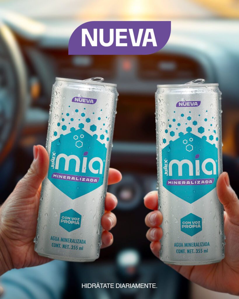 Dos latas de 355 ml de la nueva Jumex Mia Agua Mineralizada sostenidas por manos dentro de un vehículo. Las latas muestran condensación por frío, el eslogan "CON VOZ PROPIA" y están acompañadas por el título "NUEVA" en la parte superior. El mensaje inferior indica "HIDRÁTATE DIARIAMENTE".