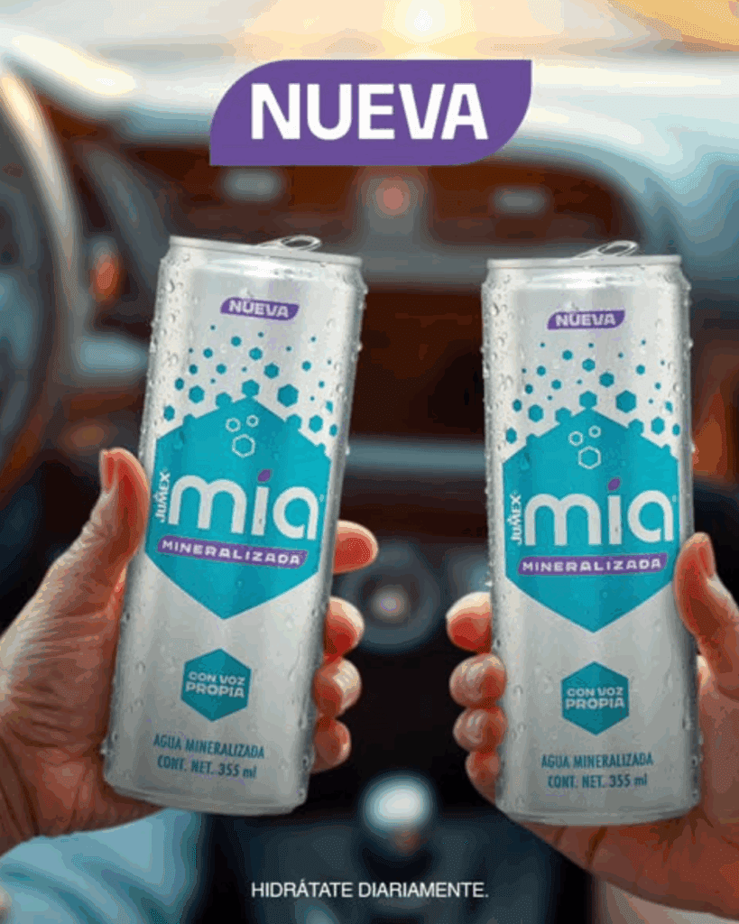 Publicidad de la lata "NUEVA" de Jumex Mia Mineralizada de 355 ml. Dos latas plateadas son sostenidas por manos en el interior de un automóvil, destacando la frase "CON VOZ PROPIA" y el mensaje "HIDRÁTATE DIARIAMENTE".